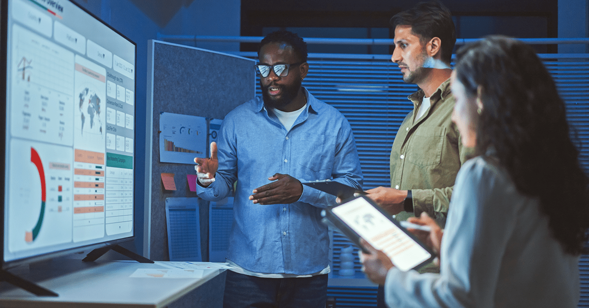 Two men and a woman looking at a dashboard together.