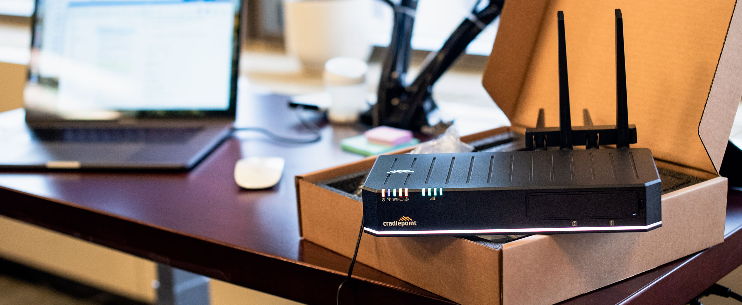 A Cradlepoint LTE Router is on an office desk during the setup of the organizations Wireless WAN.