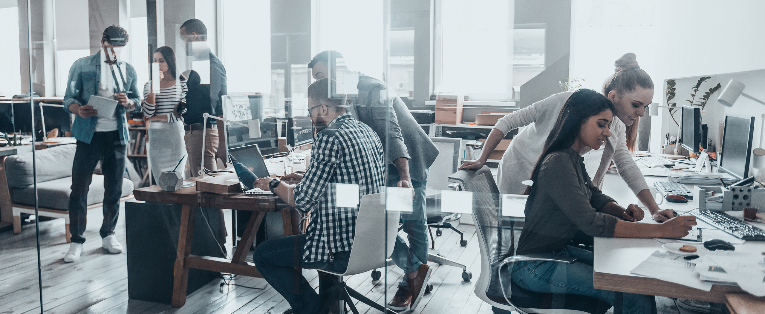 Young professionals use computers at a modern office, with connectivity to the company-wide Wireless WAN ensured through cellular broadband routers.